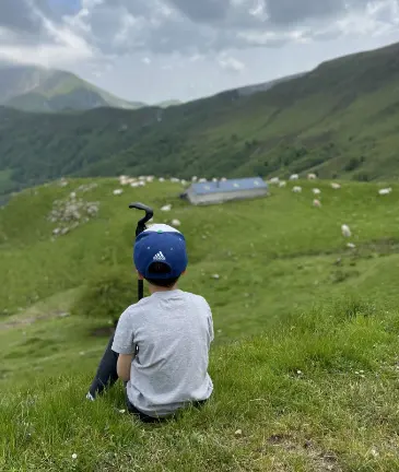 Un enfant, fait une petite pause admirant la faune du Pays Basque lors d'une randonnée pédestre.